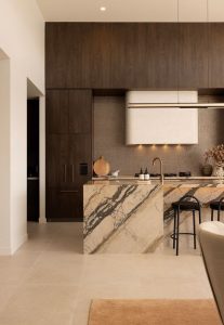 Luxury kitchen featuring Breccia Etna marble island bend and walnut cabinetry