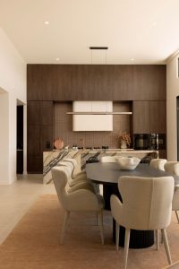 Luxury kitchen and dining room with dark walnute cabinetry and marble island bench